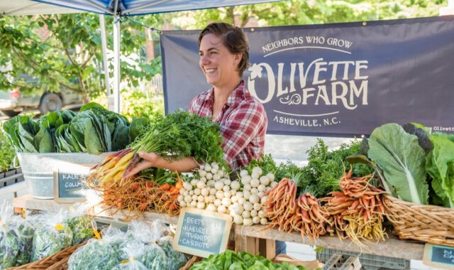 Woman selling produce at Asheville farmers market