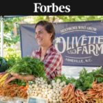 Woman selling produce at Asheville farmers market